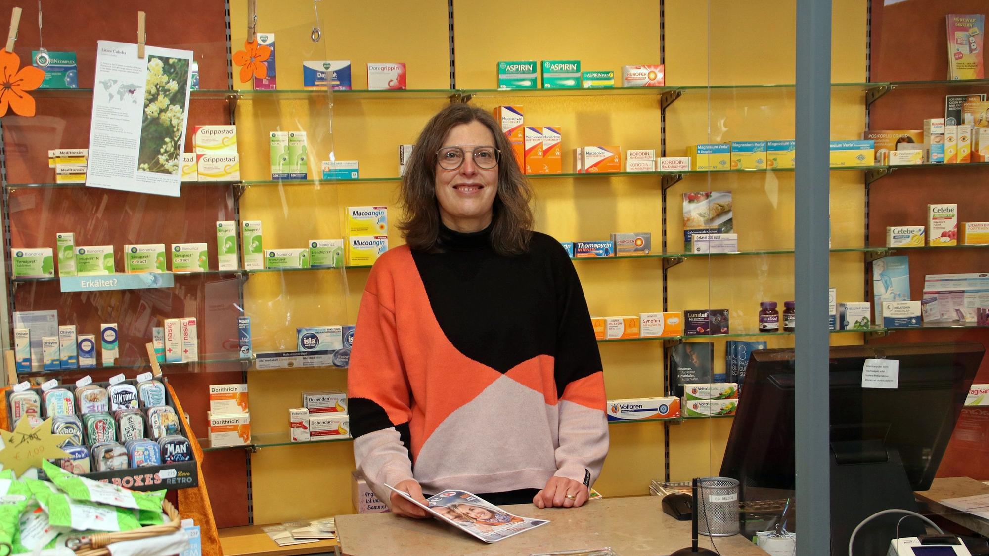 Eine Frau hinter der Verkaufstheke einer Apotheke.