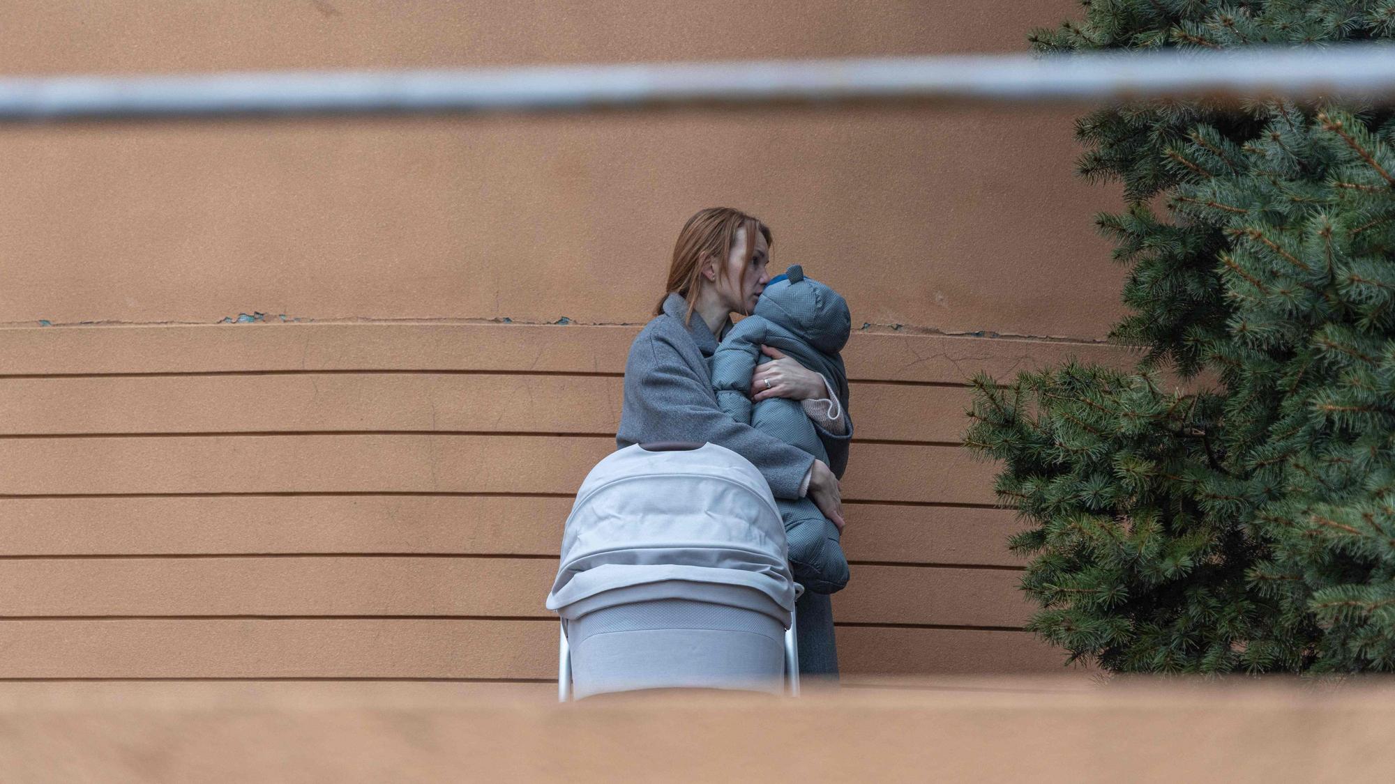 Eine Frau hält ein Baby im Arm, nachdem russische Raketen ein Wohngebiet in der ukrainischen Stadt Odessa getroffen haben.