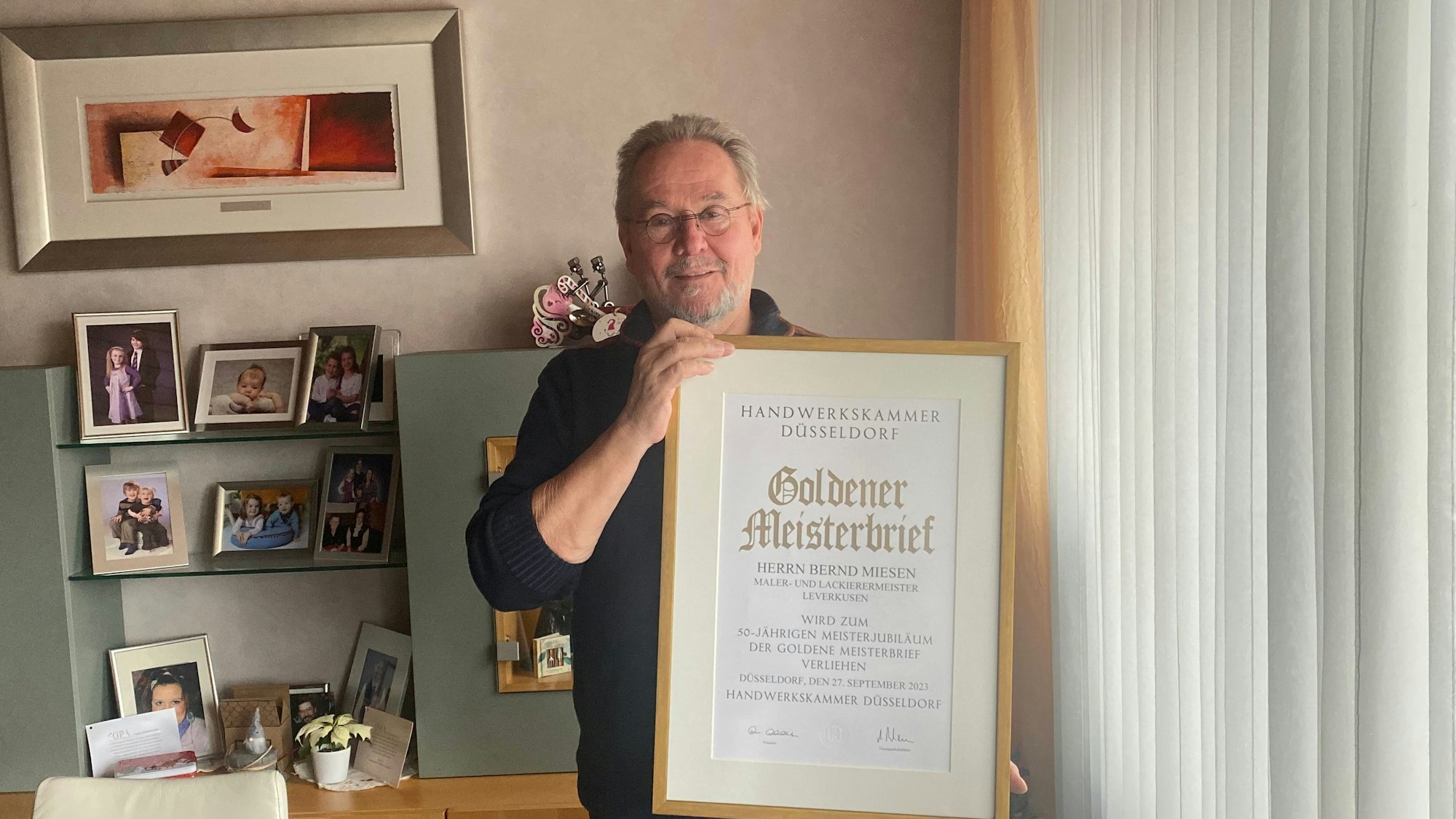 Ein Mann hält eine Urkunde.