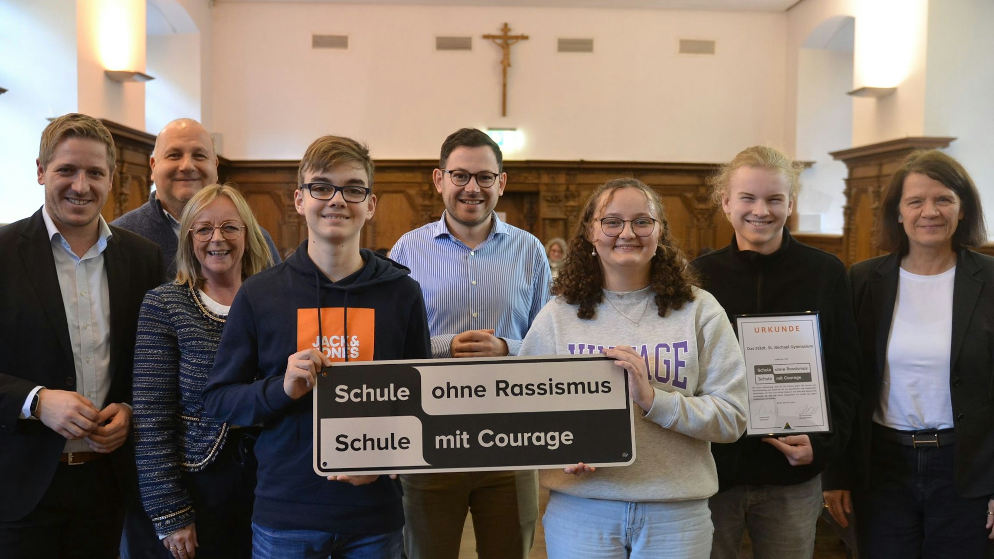 Schülerinnen und Schüler des Bad Münstereifeler St. Michael Gymnasiums zeigen das „Schule ohne Rassismus“-Plakat. Links steht Landrat Markus Ramers.