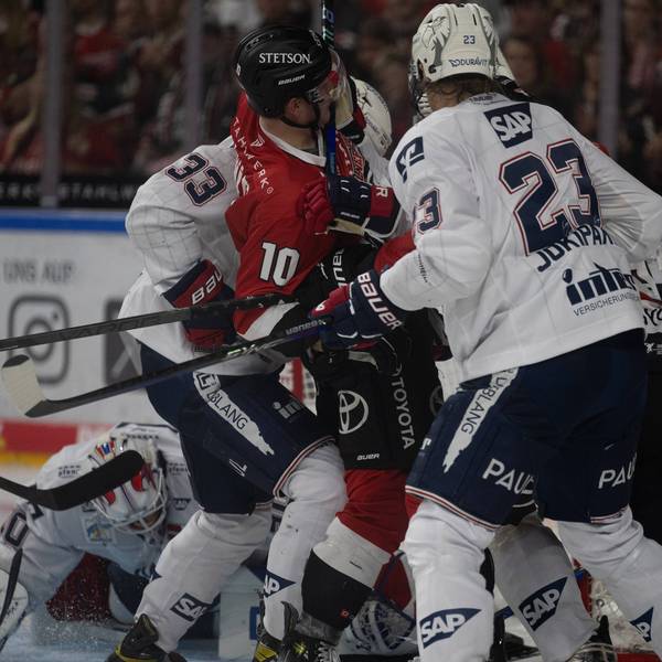 Eishockey-Spieler der Kölner Haie und Mannheimer Adler im Gerangel. Ein Spieler ist am Boden.