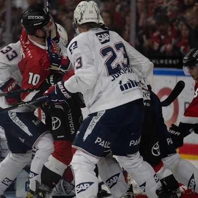 Eishockey-Spieler der Kölner Haie und Mannheimer Adler im Gerangel. Ein Spieler ist am Boden.