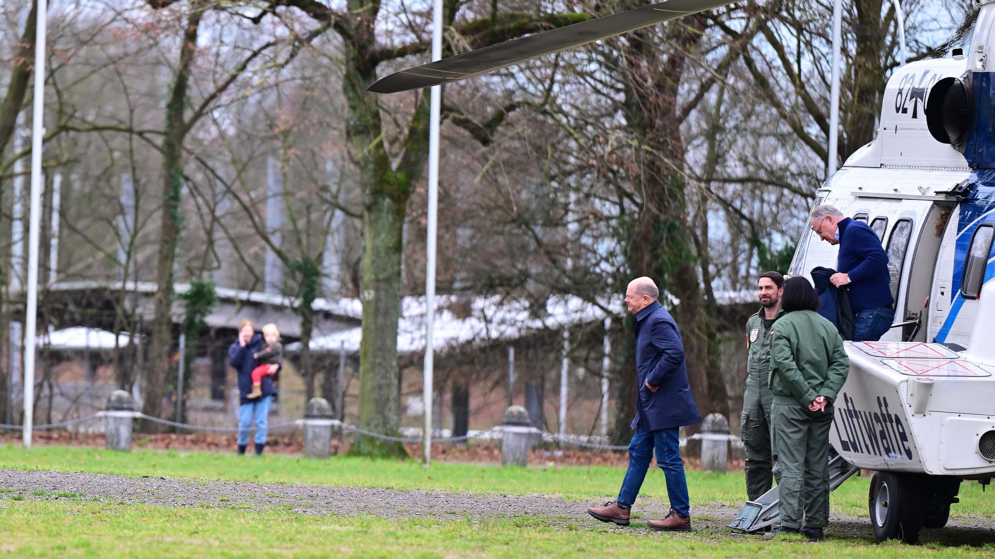 Bundeskanzler Olaf Scholz und Stephan Weil, Ministerpräsident von Niedersachsen, verlassen nach einem Rundflug über das Hochwassergebiet am Zusammenfluss von Weser und Aller den Helikopter.
