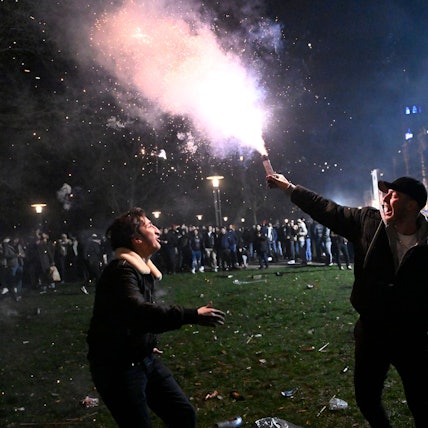 Ein Mann hält einen Feuerwerkskörper in der Hand