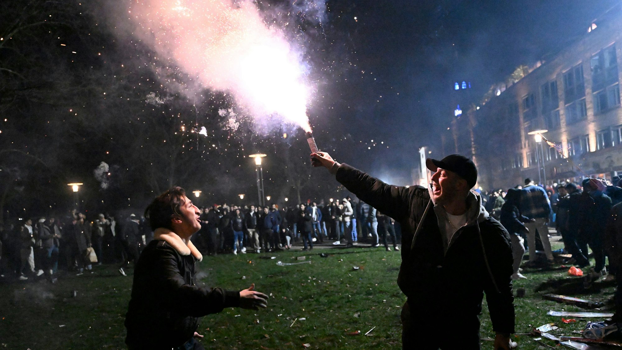 Ein Mann hält einen Feuerwerkskörper in der Hand