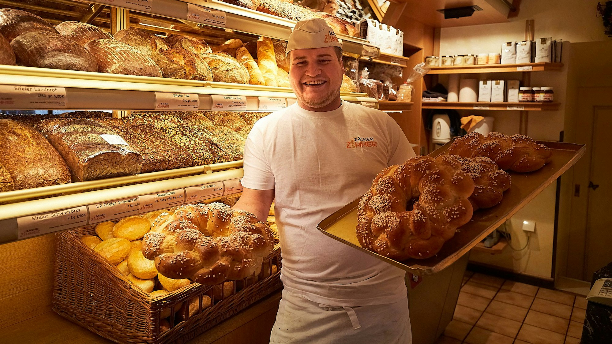Das Bild zeigt Patrick Zimmer, wie er die fertigen Neujahrskränze auf einem Tablett präsentiert.