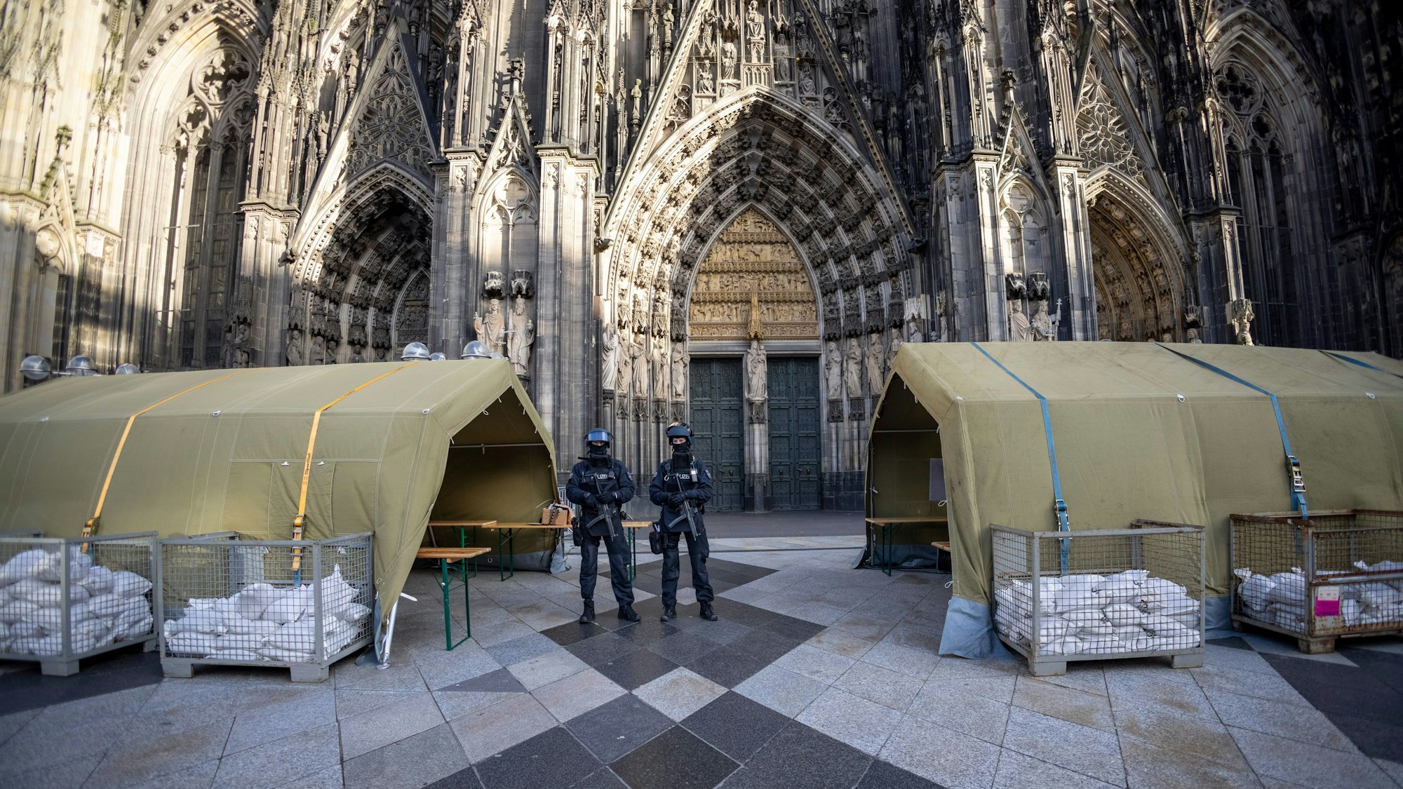 dpatopbilder - 31.12.2023, Nordrhein-Westfalen, Köln: Vor dem Pontifikalamt im Kölner Dom zum Jahresabschluss mit Kardinal Woelki wird das Domumfeld von Einsatzkräften der Polizei mit Maschinenpistolen stark bewacht. Foto: Thomas Banneyer/dpa +++ dpa-Bildfunk +++