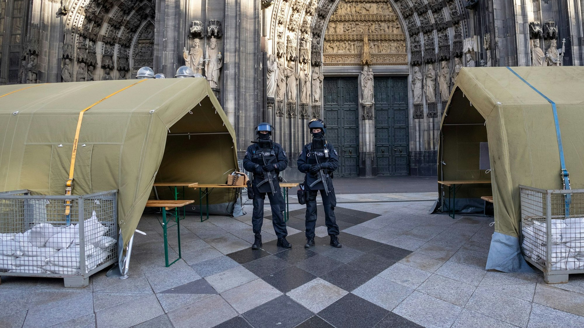 dpatopbilder - 31.12.2023, Nordrhein-Westfalen, Köln: Vor dem Pontifikalamt im Kölner Dom zum Jahresabschluss mit Kardinal Woelki wird das Domumfeld von Einsatzkräften der Polizei mit Maschinenpistolen stark bewacht. Foto: Thomas Banneyer/dpa +++ dpa-Bildfunk +++