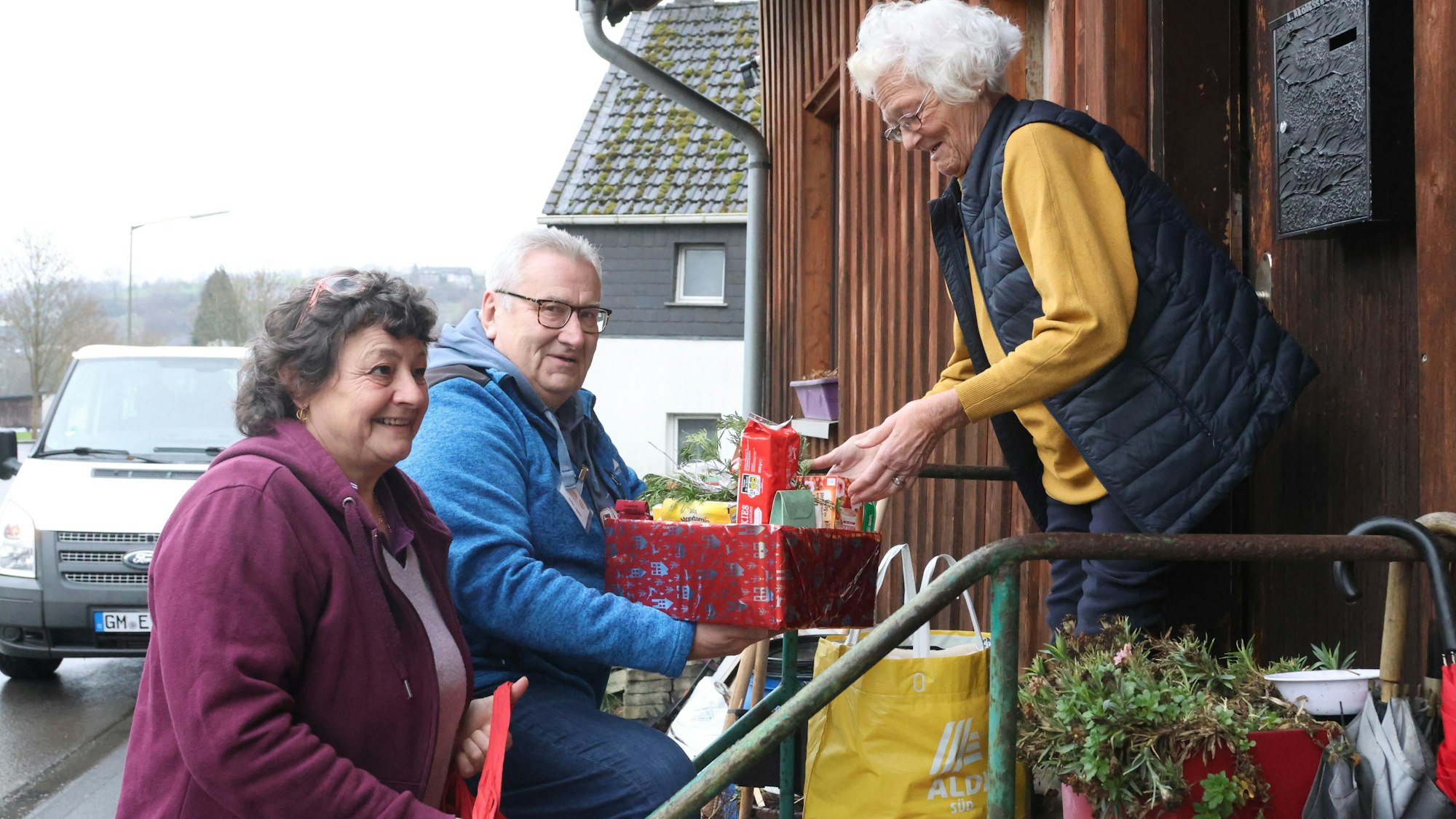 Tina Sellau und Volker Jagelki von der Tafel Oberberg-Süd beliefern eine Kundin aus Morsbach mit Waren.
