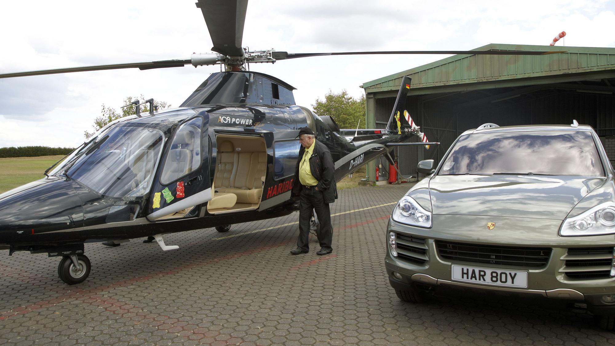 Haribo-Chef Hans Riegel 2009 neben seinem Hubschrauber und seinem Porsche Cayenne auf dem Golfplatz Jakobsberg bei Spay in der Nähe von Koblenz (Rheinland-Pfalz).