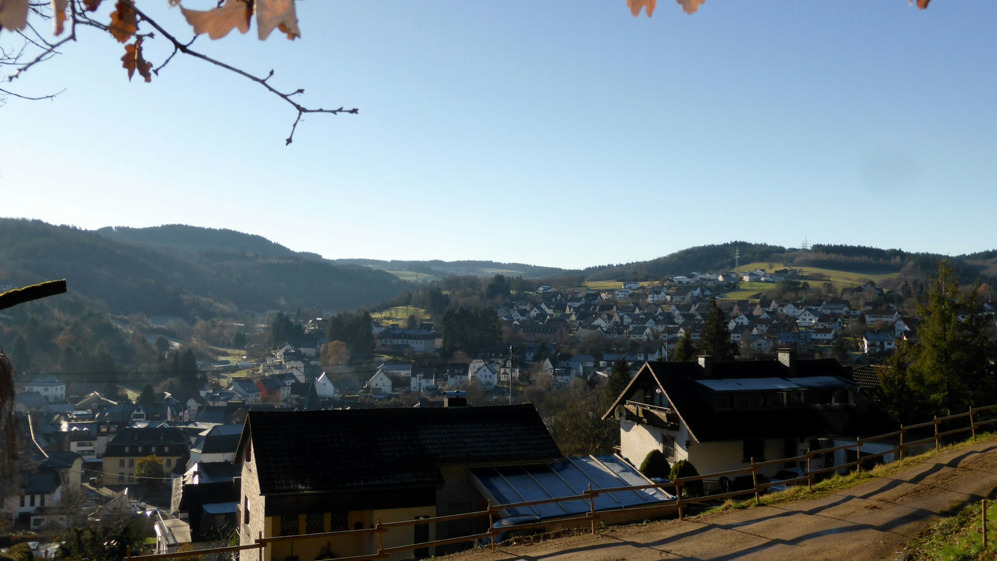 Im Sonnenuntergang ist von einer Anhöhe aus die Stadt Adenau zu sehen.