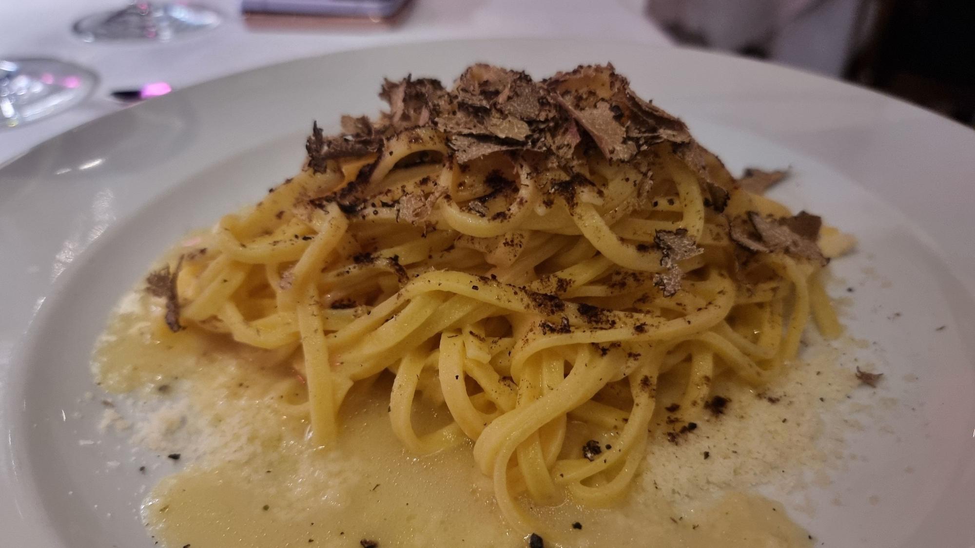 Tagliolini mit schwarzem Trüffel auf einem Teller.