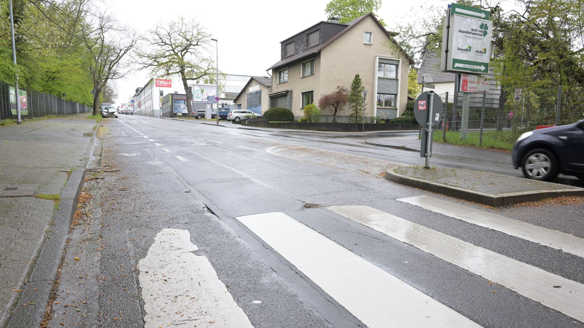 Zu sehen sind Straßenschäden an einem Zebrastreifen sowie Bordsteinen.