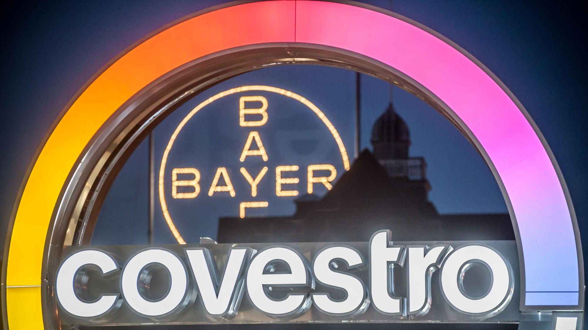 Bayerkreuz und Covestro-Logo in Leverkusen