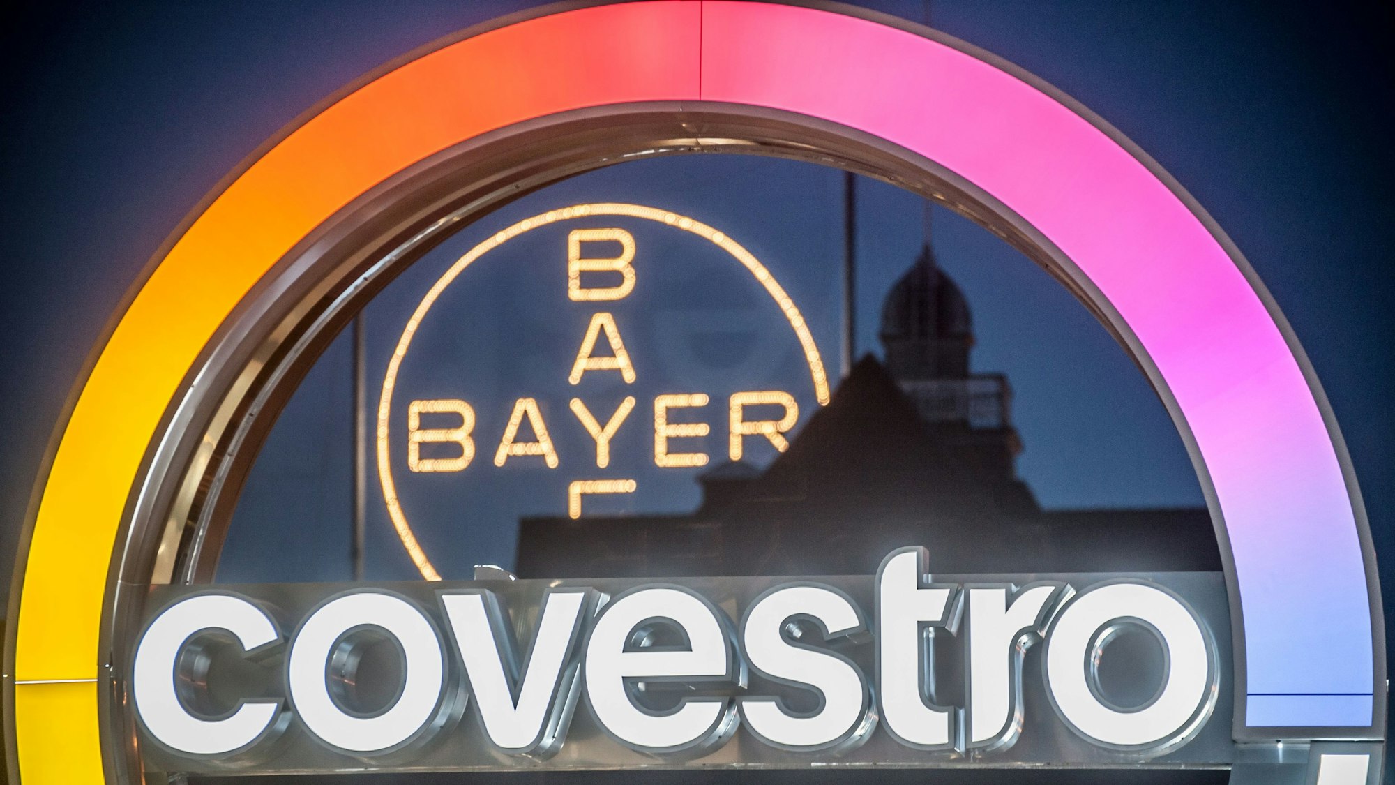 Bayerkreuz und Covestro-Logo in Leverkusen