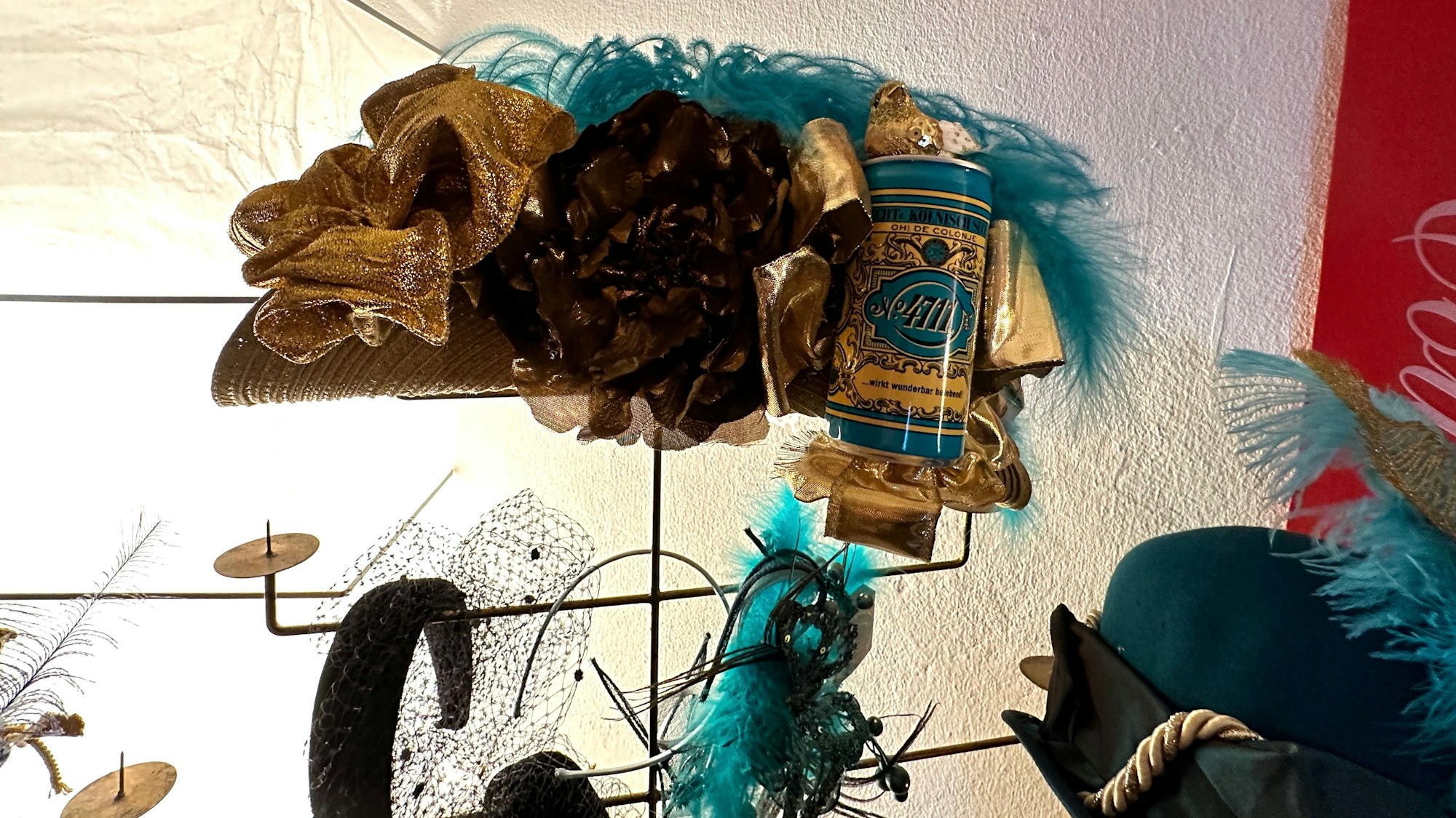 Ein Karnevalshut in den 4711-Farben Türkis und Gold ist zu sehen.