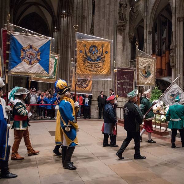 Im Januar 2023 tragen Karenvalisten Flaggen in Richtung des Altars des Kölner Doms.