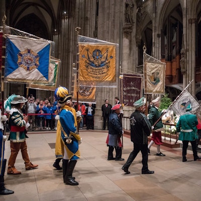 Im Januar 2023 tragen Karenvalisten Flaggen in Richtung des Altars des Kölner Doms.