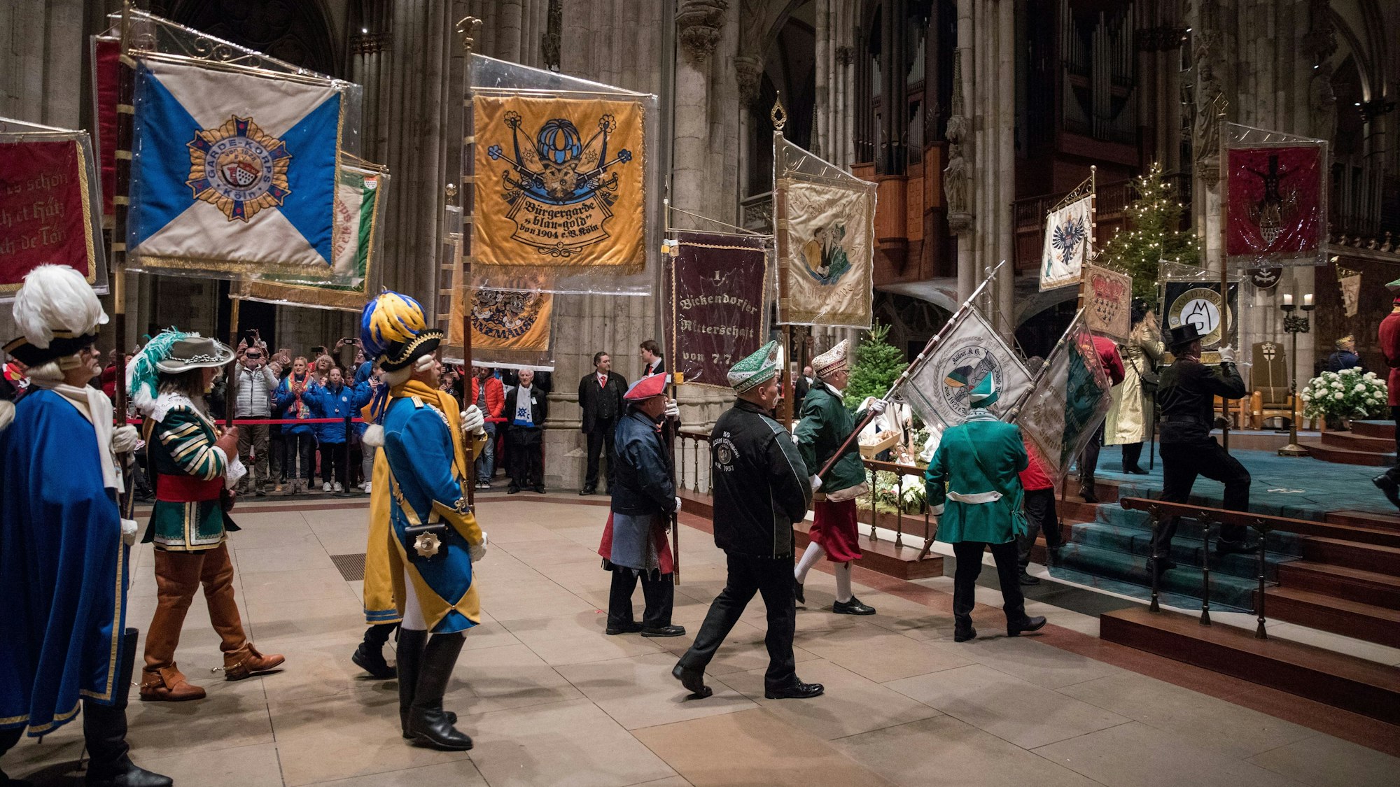 Im Januar 2023 tragen Karenvalisten Flaggen in Richtung des Altars des Kölner Doms.