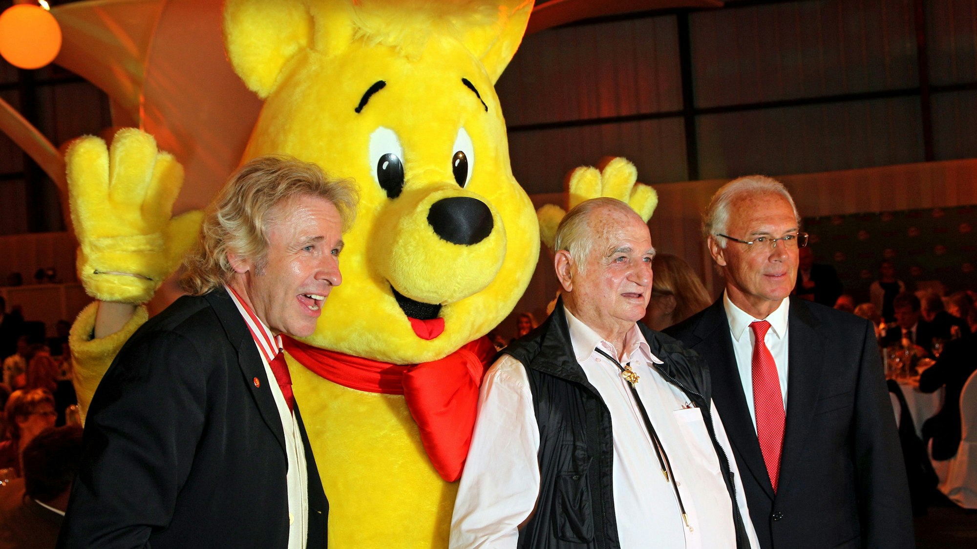 Der Moderator Thomas Gottschalk (l-r), der langjährige Haribo-Firmenchef Hans Riegel und der Ehrenpräsident des FC Bayern, Franz Beckenbauer, stehen 2010 bei der Haribo Charity Golf Challenge auf dem Golfplatz Jakobsberg bei Boppard neben dem Haribo-Goldbären.