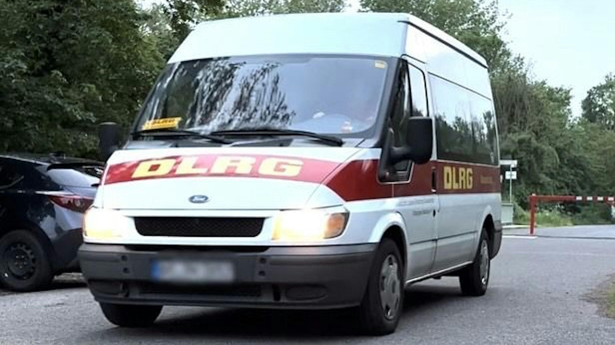 Zu sehen ist ein weißes Fahrzeug mit DLRG-Schriftzug.