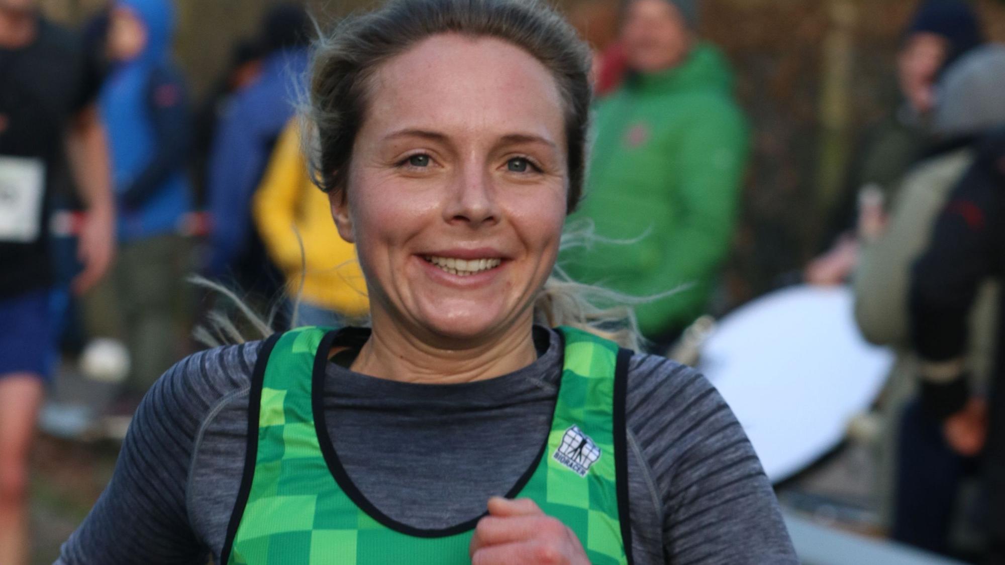 Nora Schmitz auf der Laufstrecke, sie lächelt in die Kamera.