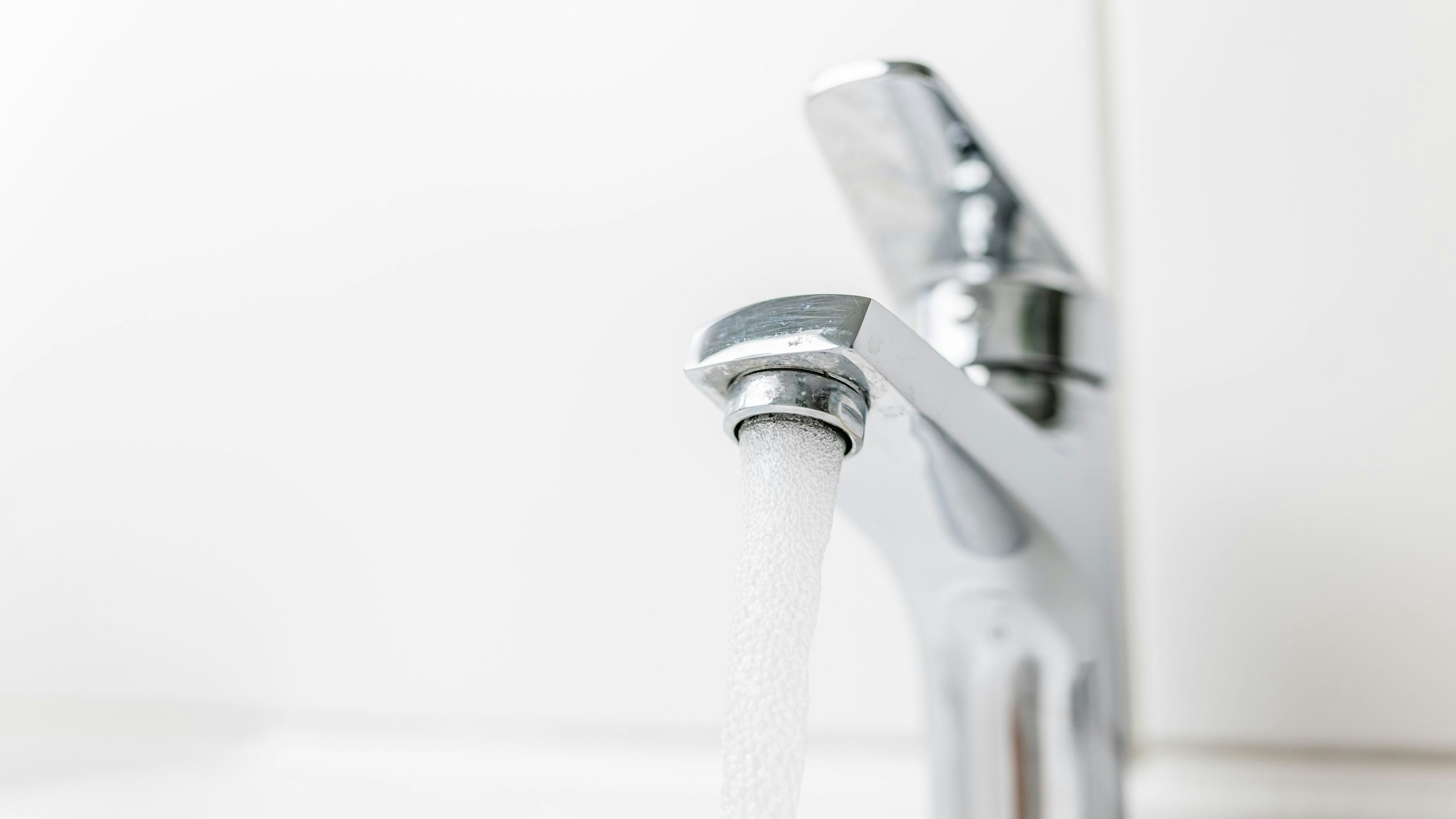 Zu sehen ist ein Wasserhahn, aus dem Wasser fließt.