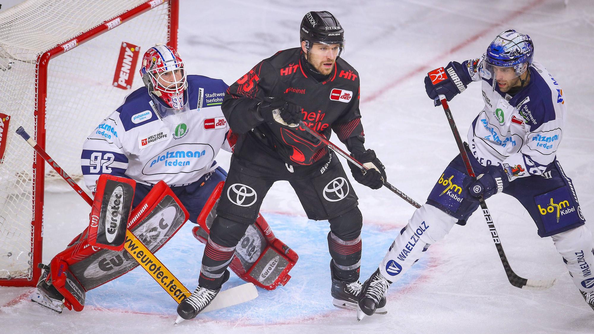Eishockeyspieler stehen dich gedrängt vor einem Tor.