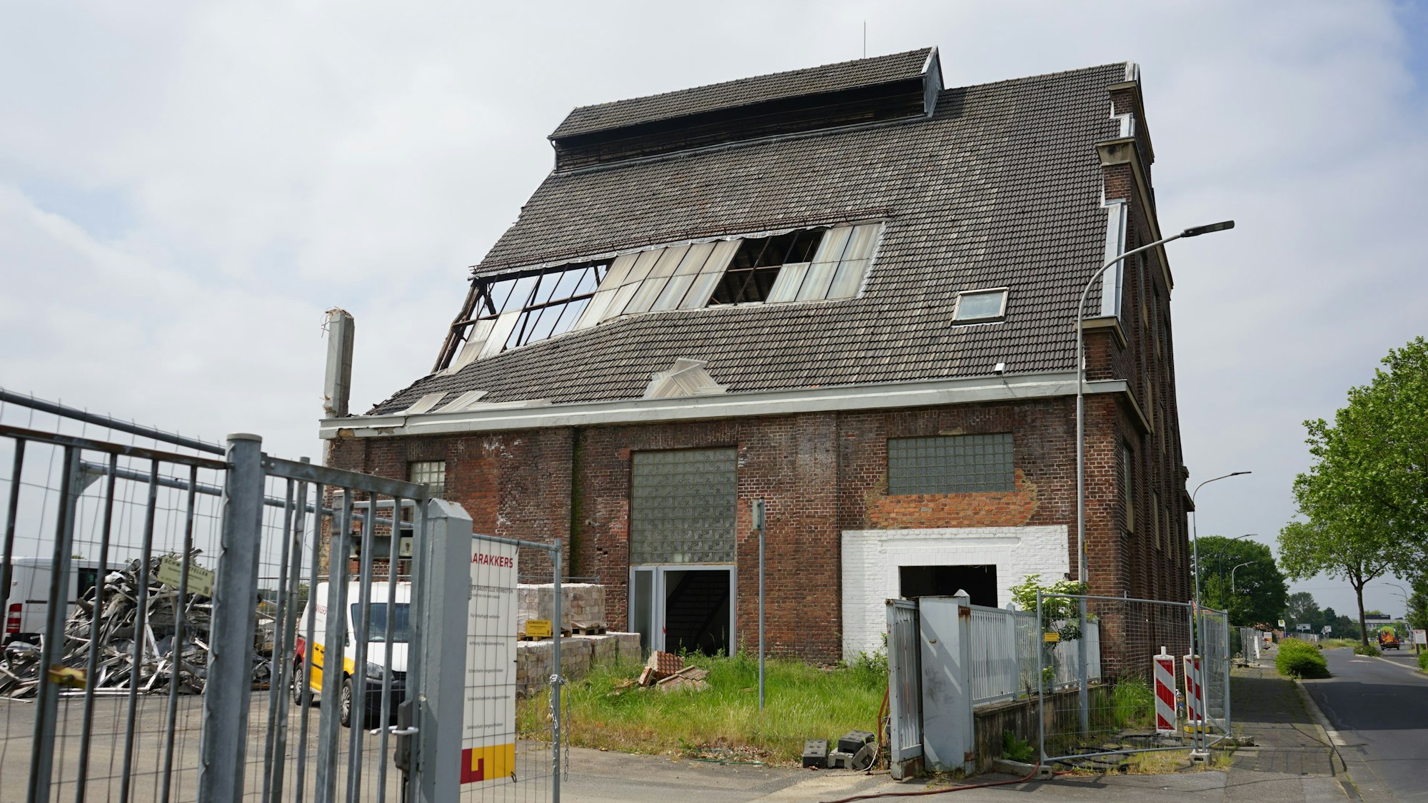 Ein Gebäude der alten Glasfabrik. Fenster sind kaputt, Ziegel bröckeln.