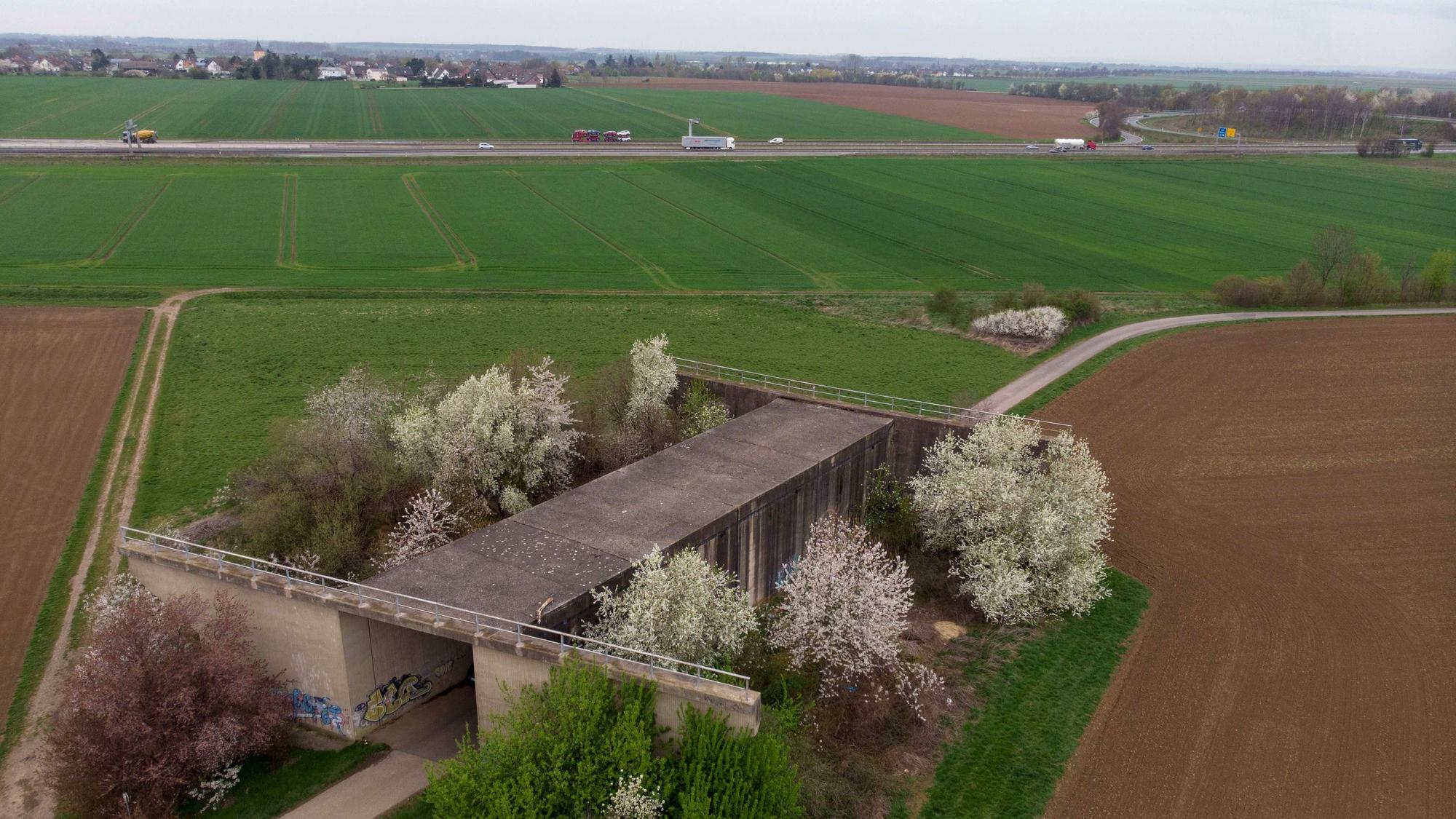 Die Brücke steht inmitten der Felder, keine Straße führt darüber.