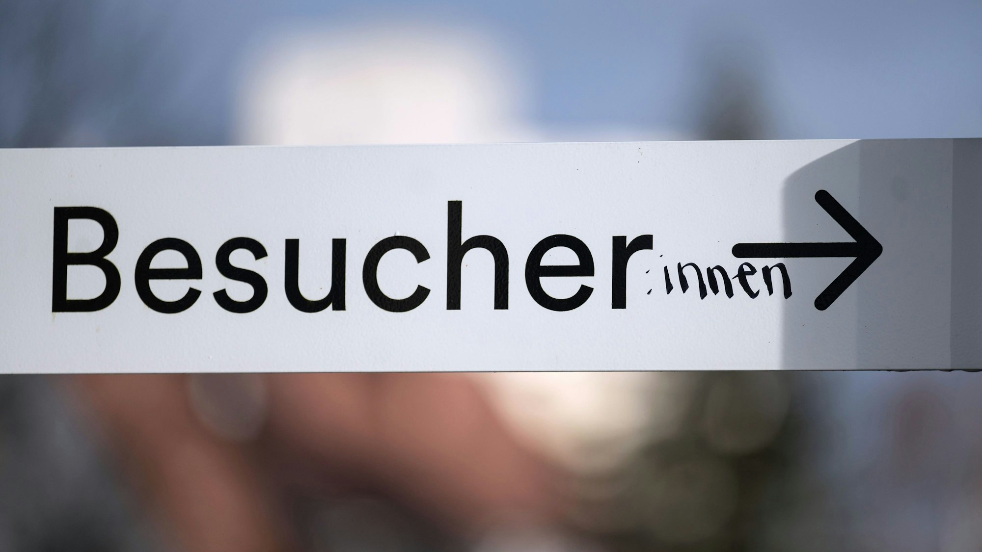 Auf einem Schild mit der Schrift „Besucher“ hat jemand handschriftlich die weibliche Form „innen“ ergänzt.