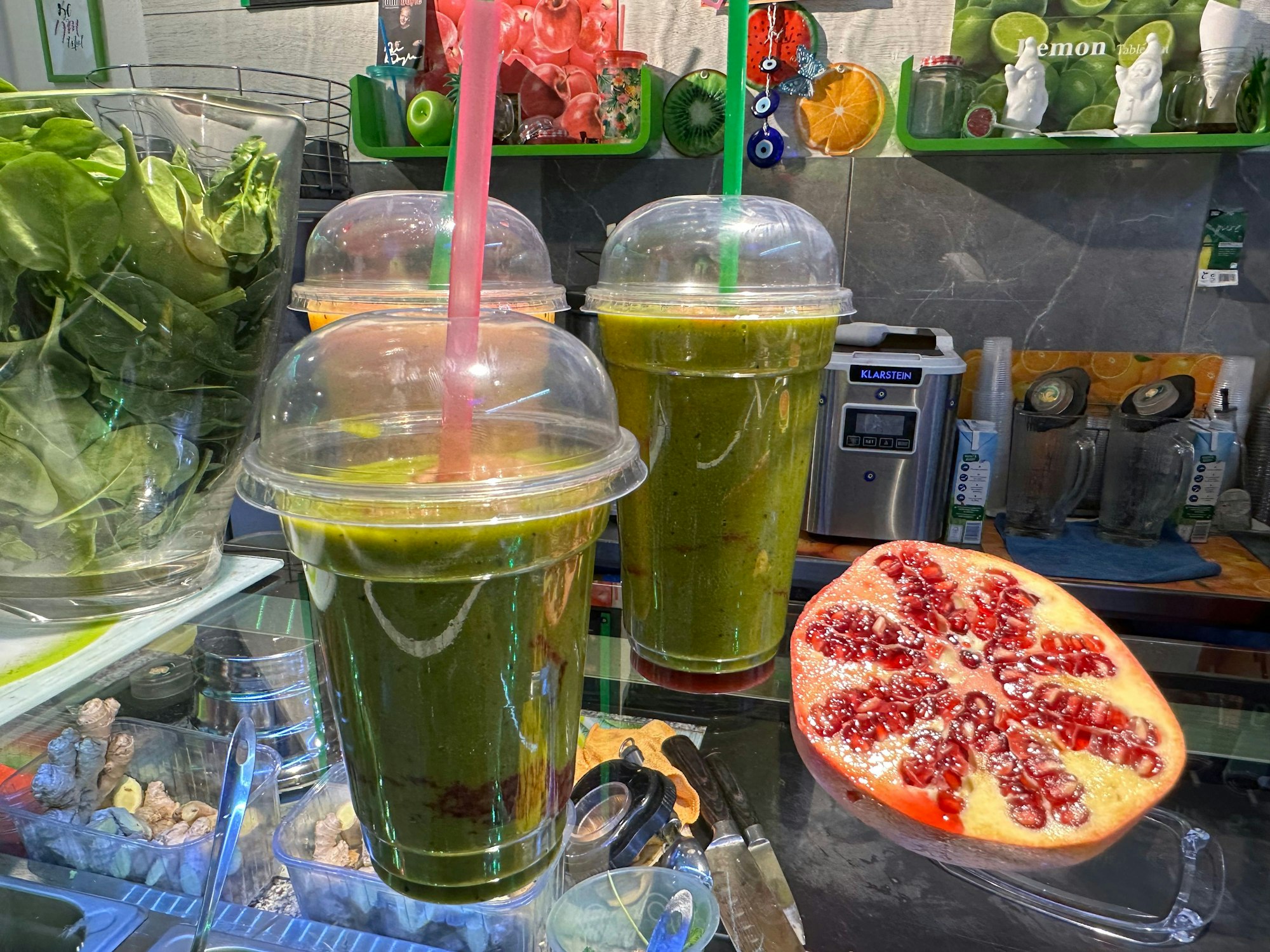 Grüne Smoothies stehen auf einem Glastresen.