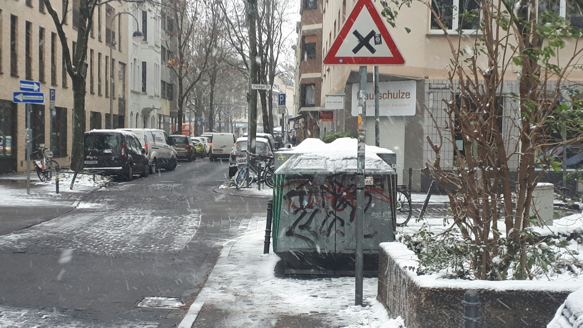 Ein Glascontainer steht auf dem Bürgersteig.
