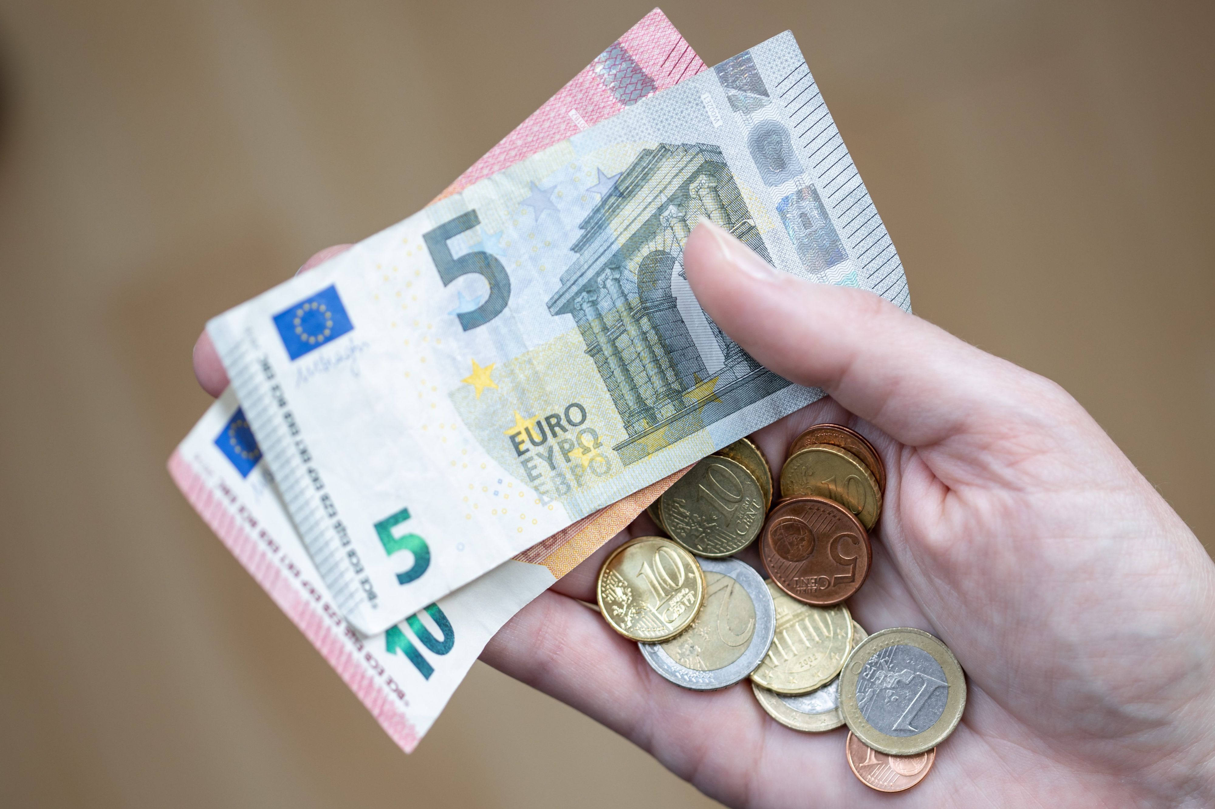 ARCHIV - 09.04.2021, Bayern, Nürnberg: Eine Frau hält Geldscheine und Münzen in der Hand. Der Kampf gegen steigende Verbraucherpreise gehört einer Umfrage zufolge für viele zu den wichtigsten Aufgaben der Politik im neuen Jahr. (Zu dpa "Umfrage: Kampf gegen Inflation für viele Menschen wichtiges Thema") Foto: Daniel Karmann/dpa +++ dpa-Bildfunk +++