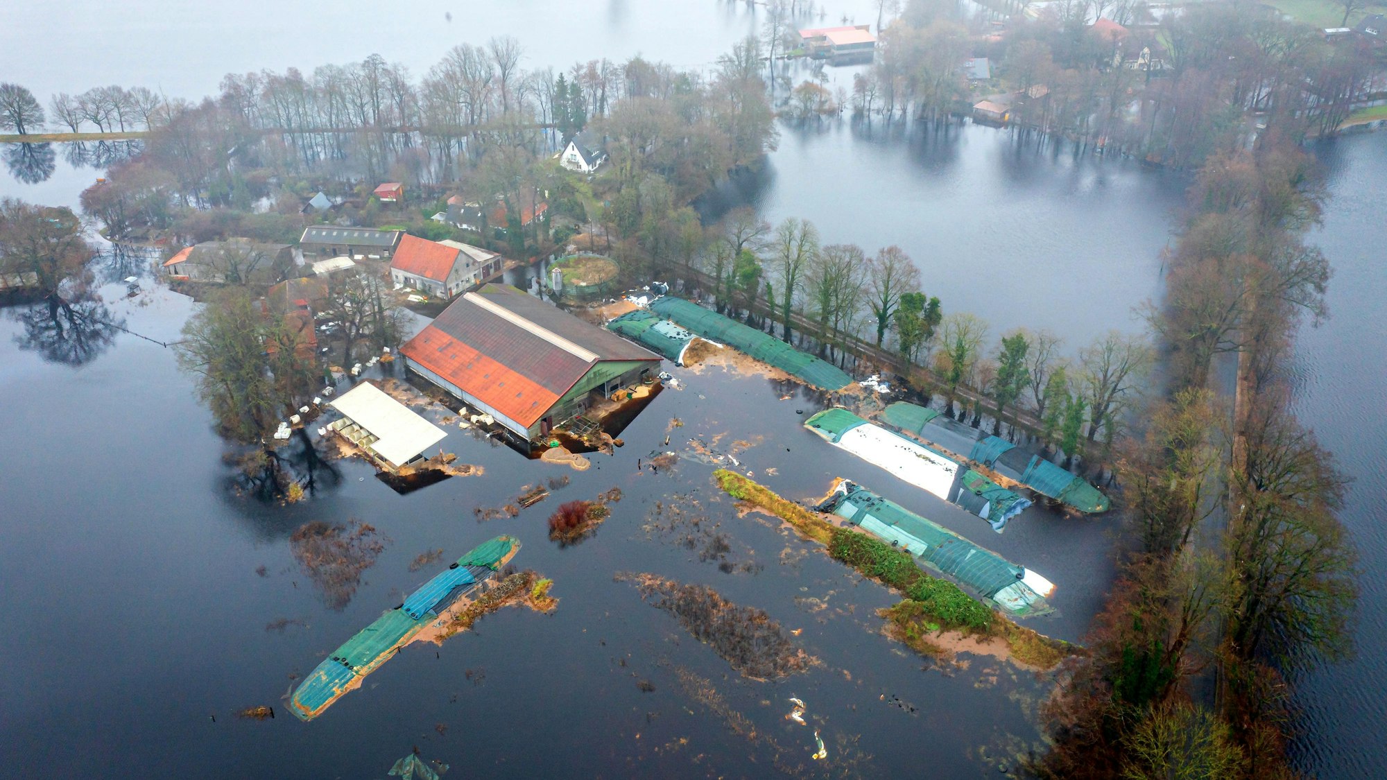 dpatopbilder - 02.01.2024, Niedersachsen, Timmersloh: Ein Bauernhof im Bremer Stadtteil Timmersloh steht unter Wasser (Luftaufnahme mit einer Drohne). Nach den Vorhersagen des Deutschen Wetterdienstes (DWD) ist weiterhin mit starkem Regen zu rechnen, so dass die Lage angespannt bleibt. Foto: Sina Schuldt/dpa +++ dpa-Bildfunk +++