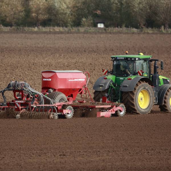 Ein Landwirt sät ein Feld frisch ein.