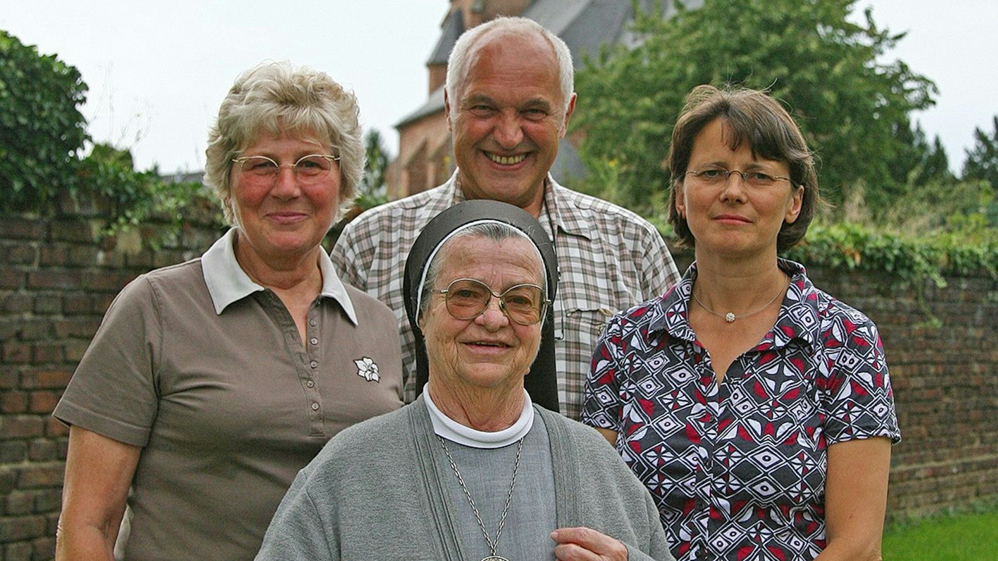 Das Foto zeigt Schwester Jutta, Konrad und Gertrud Hamacher sowie ihre Nichte Petra. Im Hintergrund ist die Kirche St. Hubertus zu sehen.
