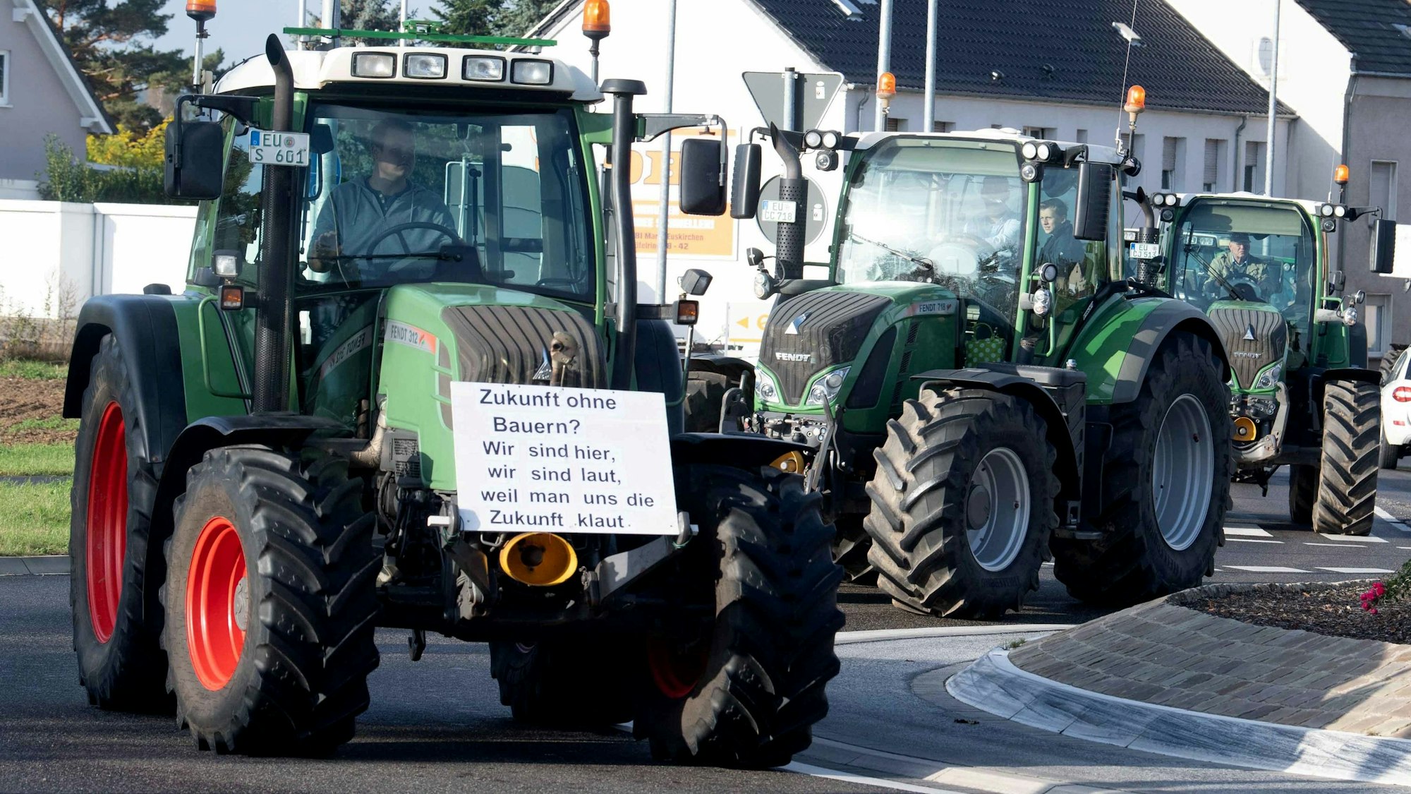 Auf dem Foto sind mehrere Traktoren zu sehen, die Konvoi fahren.