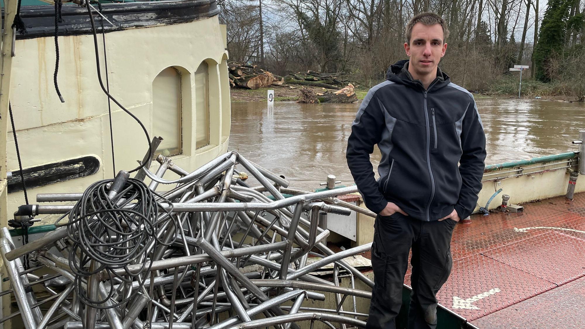 Fährmann Niklas Thiel steht auf dem "Krokolino" inmitten von Metallschrott.
