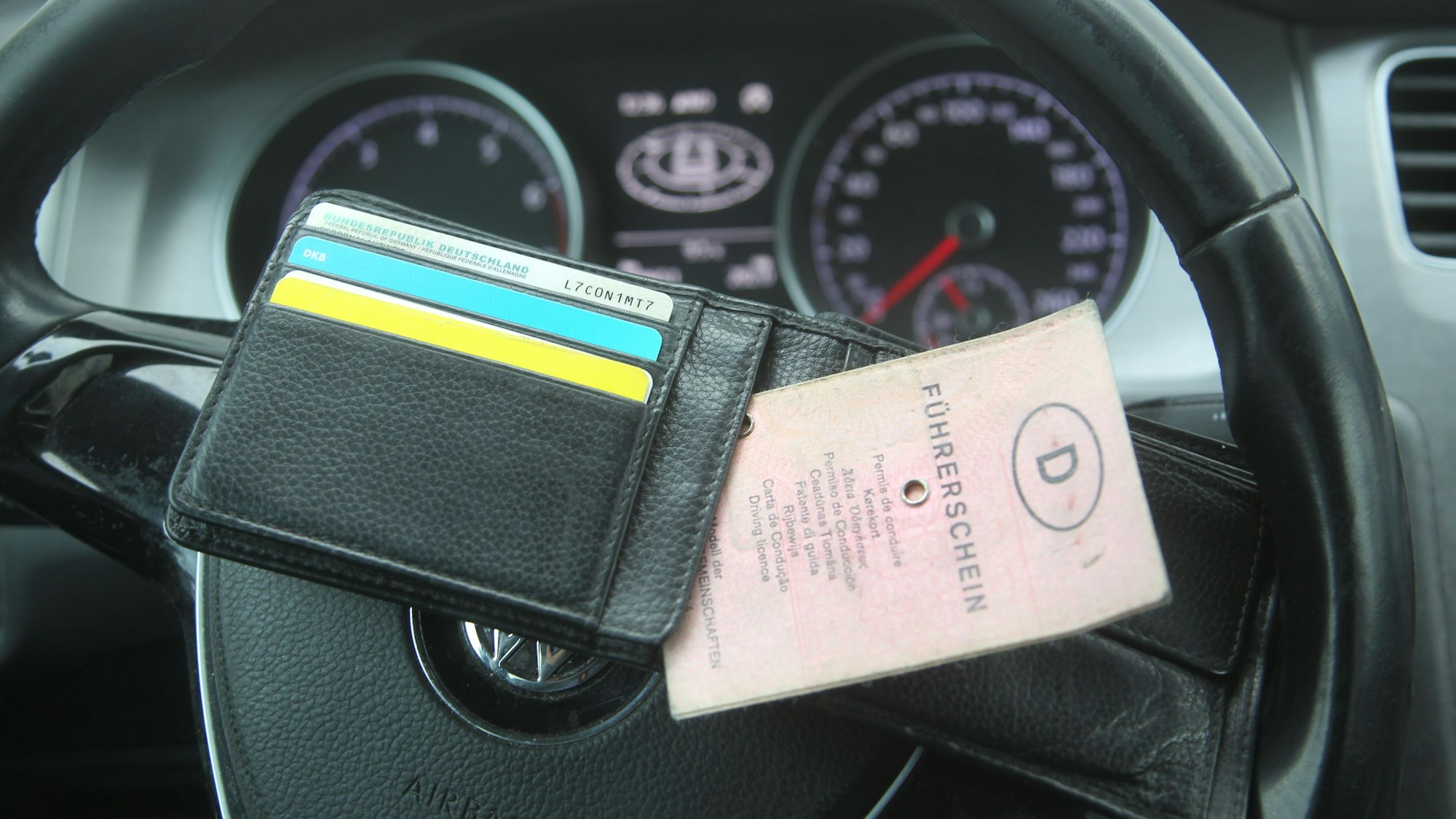 Ein Führerschein liegt auf einem Lenkrad.