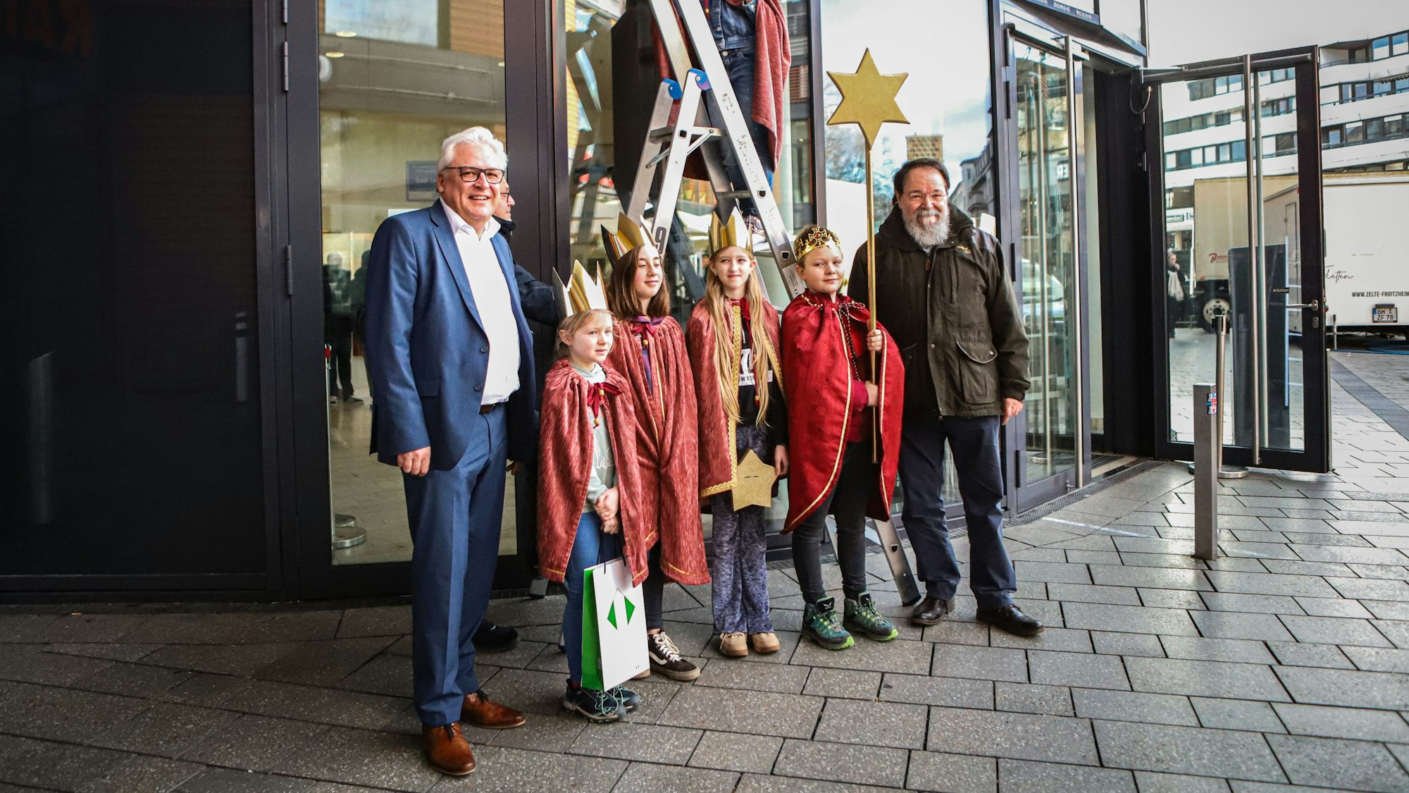 Bürgermeister Bernhard Marewski und Stadtdirektor Marc Adomat empfangen vier junge als Könige verkleidete Sternsinger am Rathaus Leverkusen.