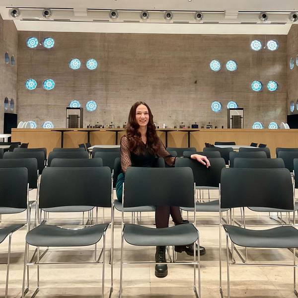 Frau in einer Stuhlreihe in einem Event-Room, der früher eine Kirche war.