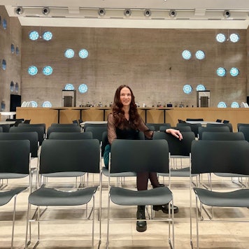 Frau in einer Stuhlreihe in einem Event-Room, der früher eine Kirche war.