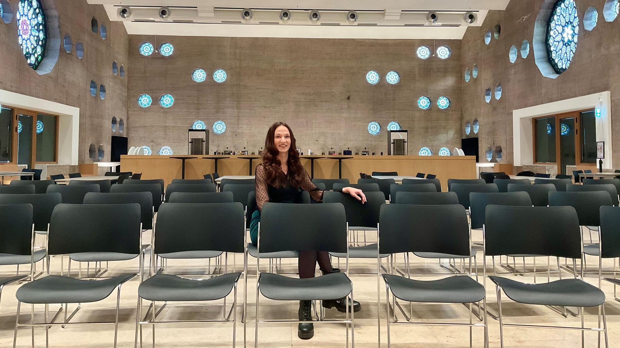 Frau in einer Stuhlreihe in einem Event-Room, der früher eine Kirche war.