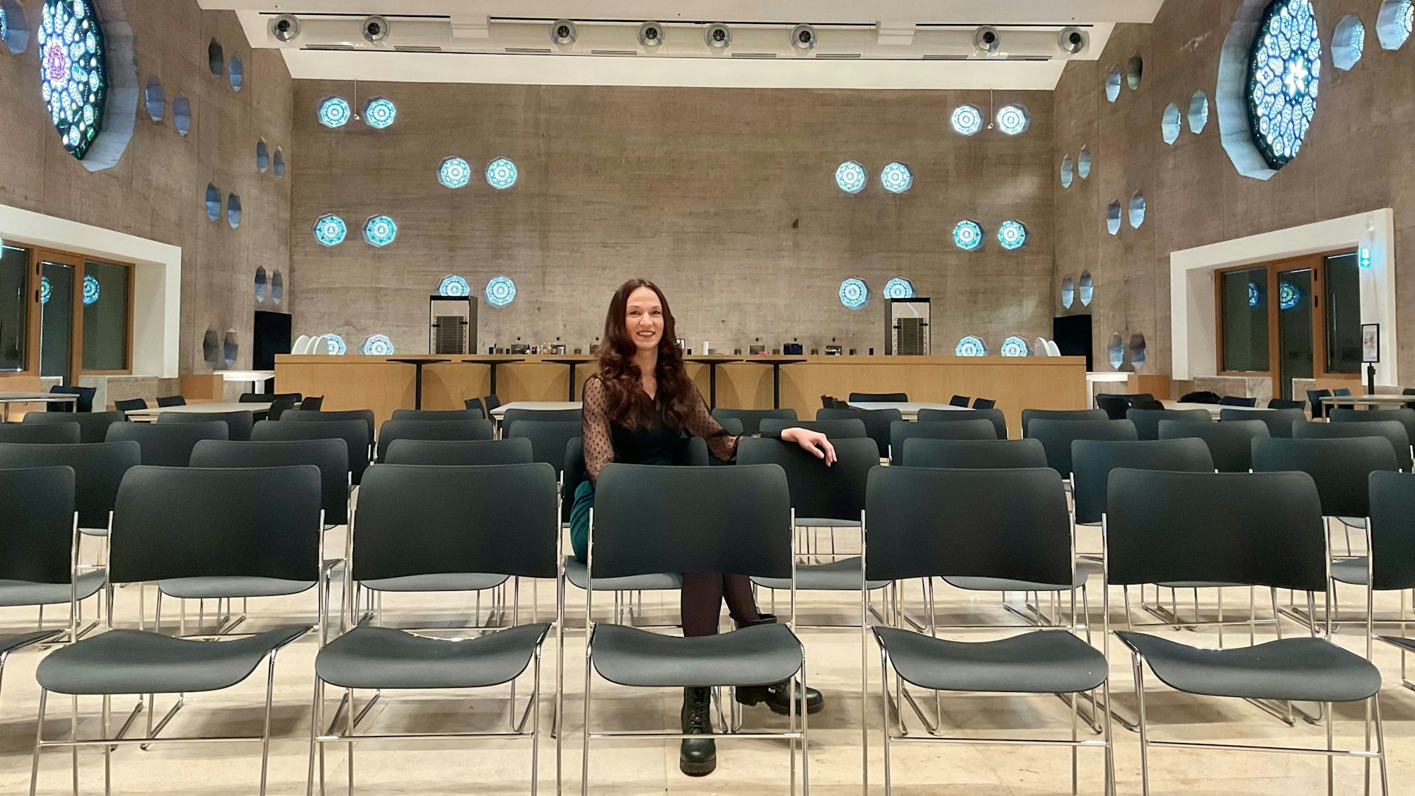 Frau in einer Stuhlreihe in einem Event-Room, der früher eine Kirche war.