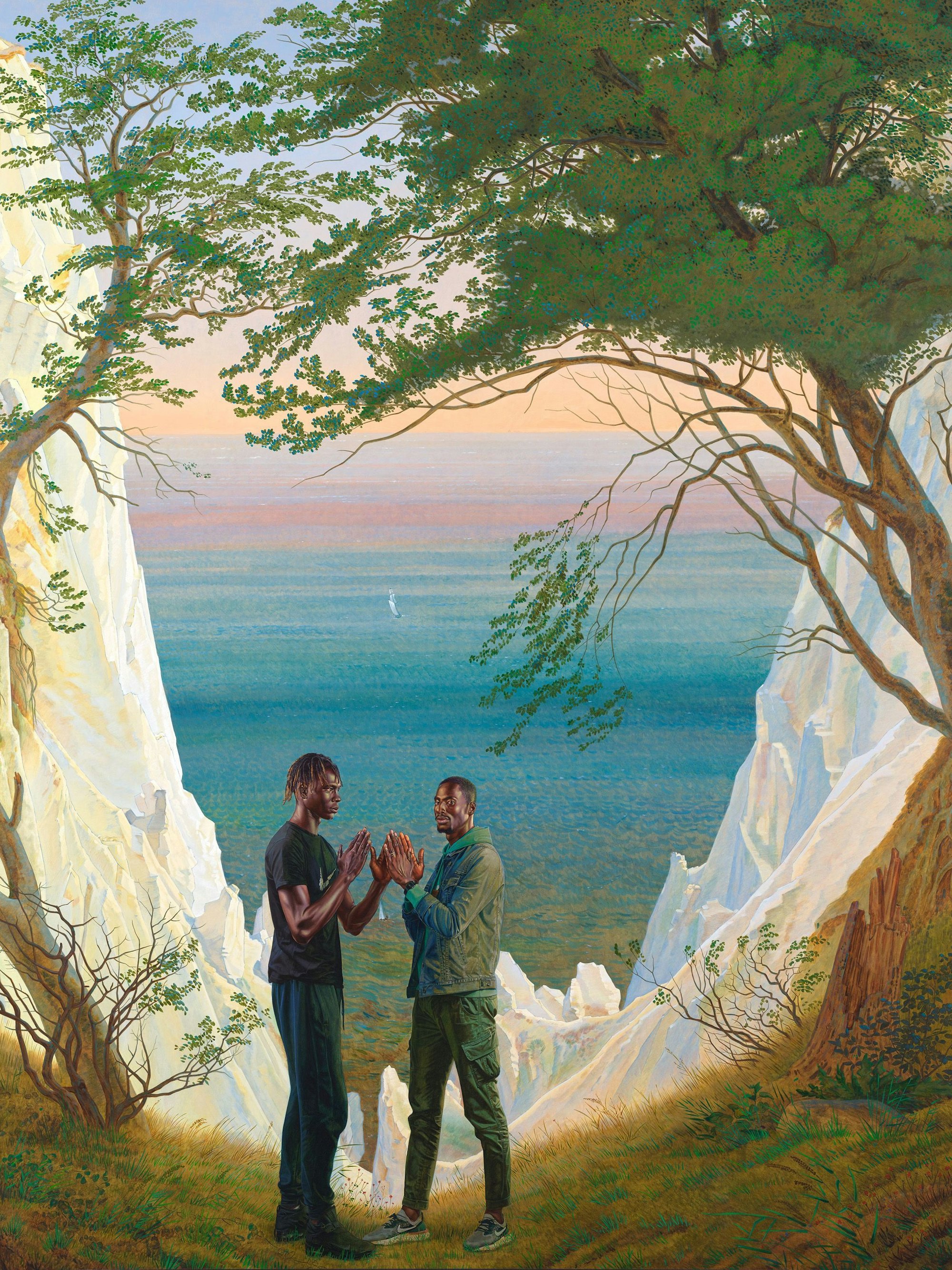 Zwei schwarze Männer stehen vor den Kreidefelsen auf Rügen und klatschen einander ab.