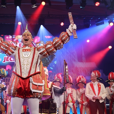 Dreigestirn jubelt im Ornat auf der Bühne.