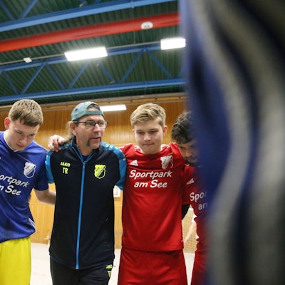 Blick auf ein Fußballteam, das sich im Kreis bespricht.