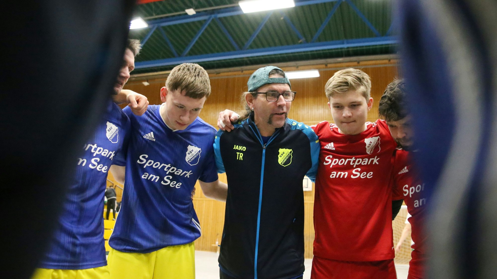 Blick auf ein Fußballteam, das sich im Kreis bespricht.