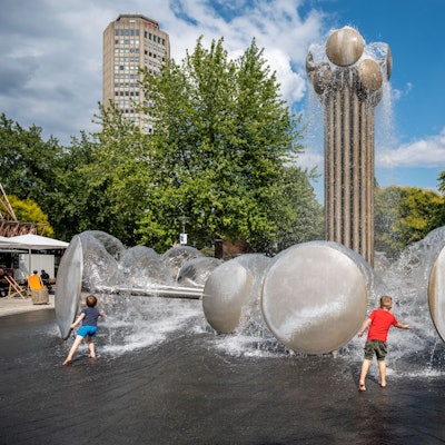 Kinder spielen am Brunnen auf dem Ebertplatz.